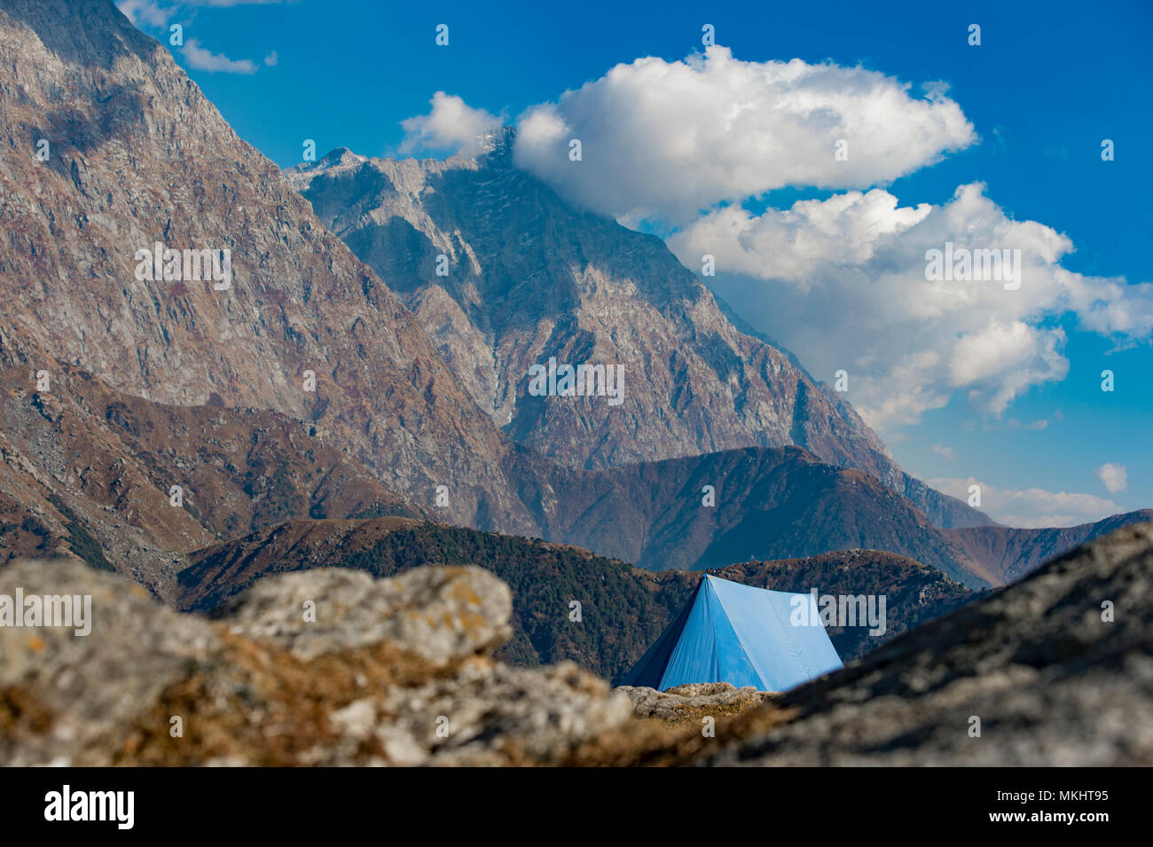 Un unico colore blu tenda visto contro Dhaulahaar vette dell'Himalaya in Triund. Giornata soleggiata con alcune nuvole. Dharamshala, Himachal Pradesh. India Foto Stock