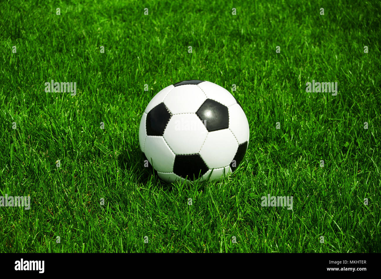 Pallone da calcio in bianco e nero classico in erba verde da soli con uno spazio Foto Stock