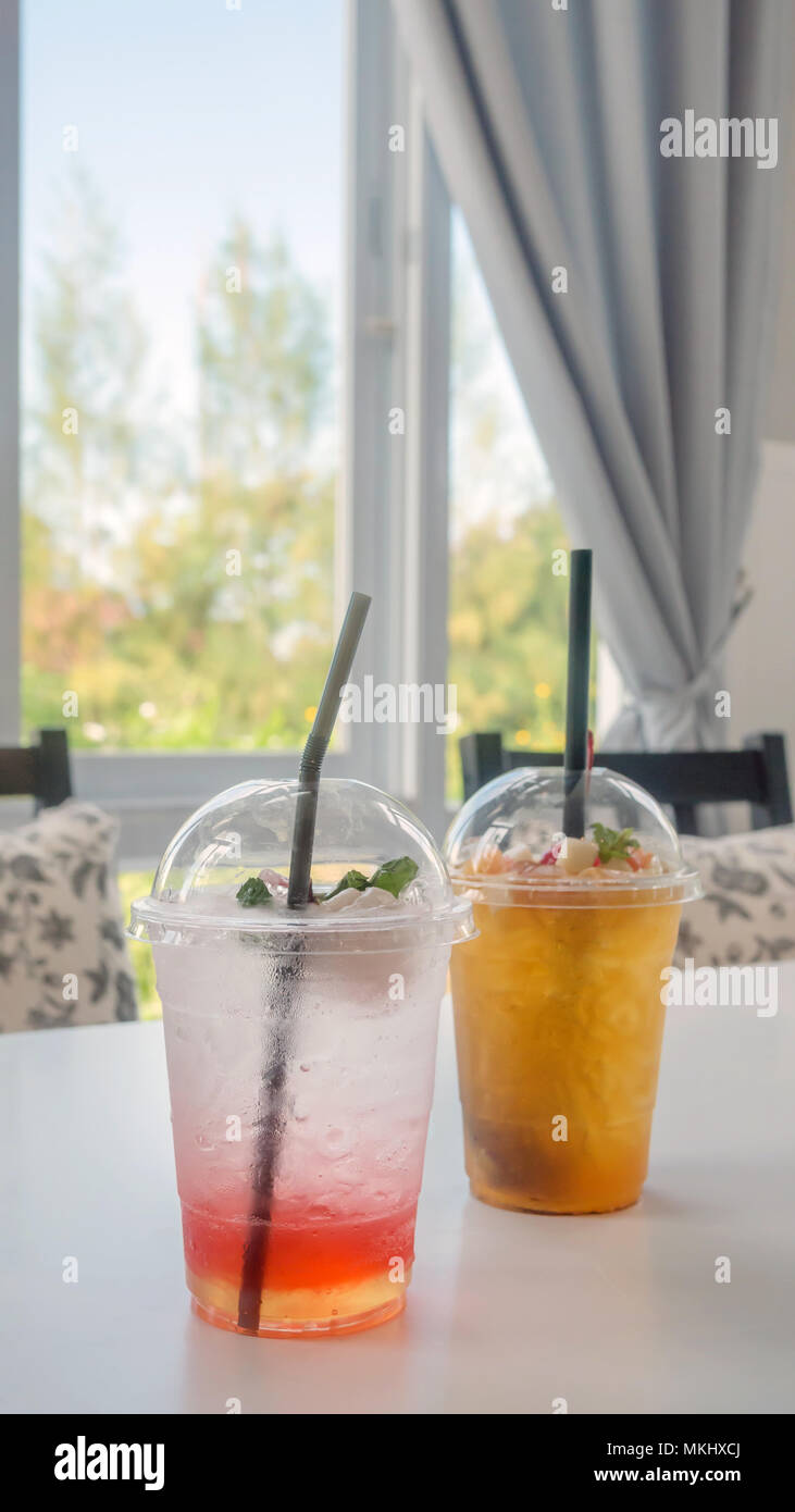 Cocktail con fresca frutta affettata disposti in bicchieri di plastica Foto Stock