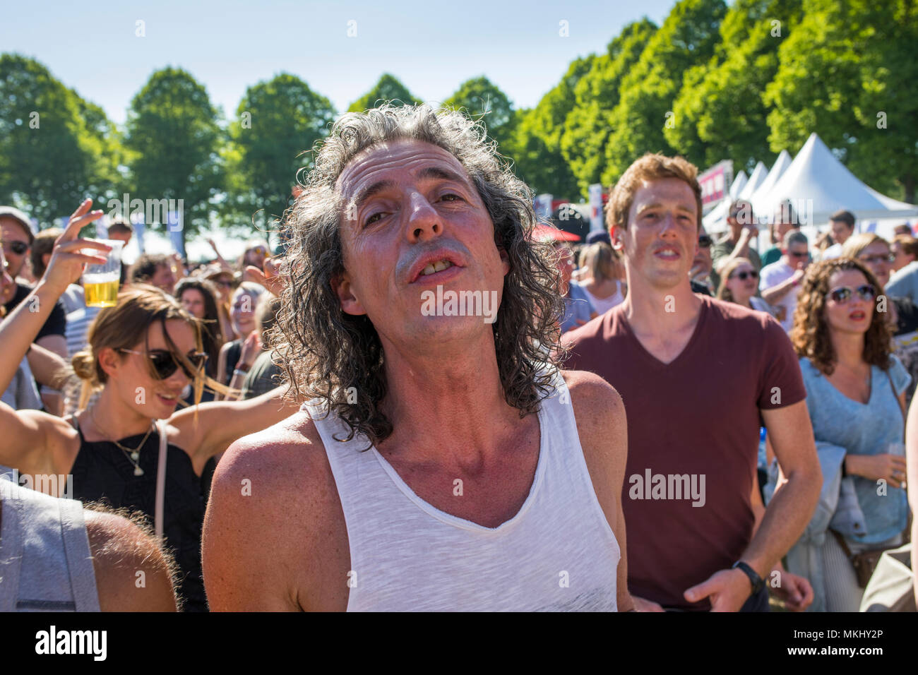 Uomo di mezza età con capelli lunghi intensamente godendo di musica alla festa di liberazione nei Paesi Bassi Foto Stock