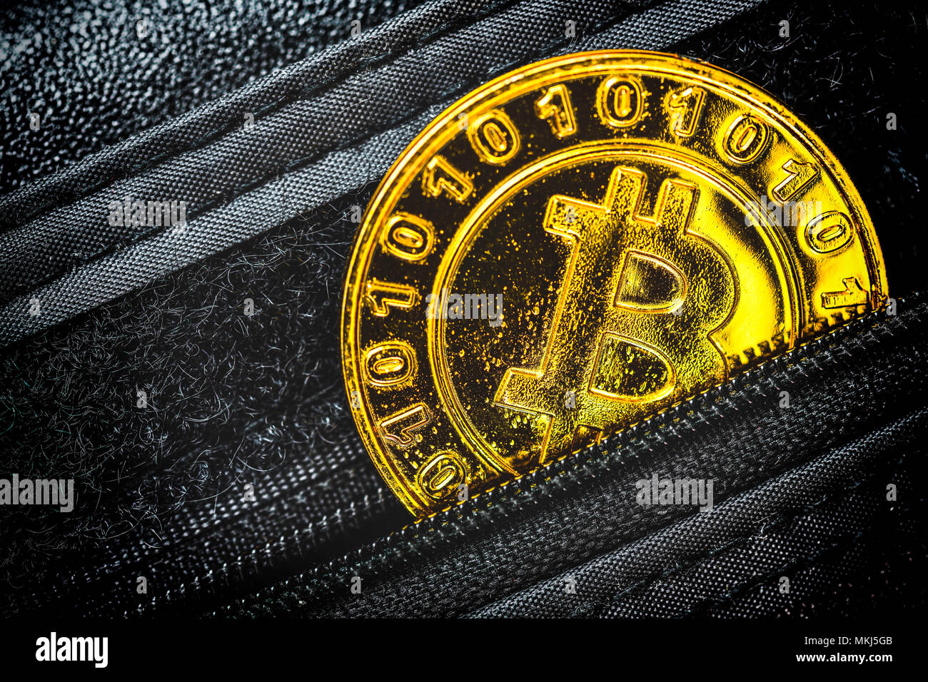 Moneta con caratteri bitcoin in un portafoglio Münze mit Bitcoin-Zeichen in einem Portemonnaie Foto Stock