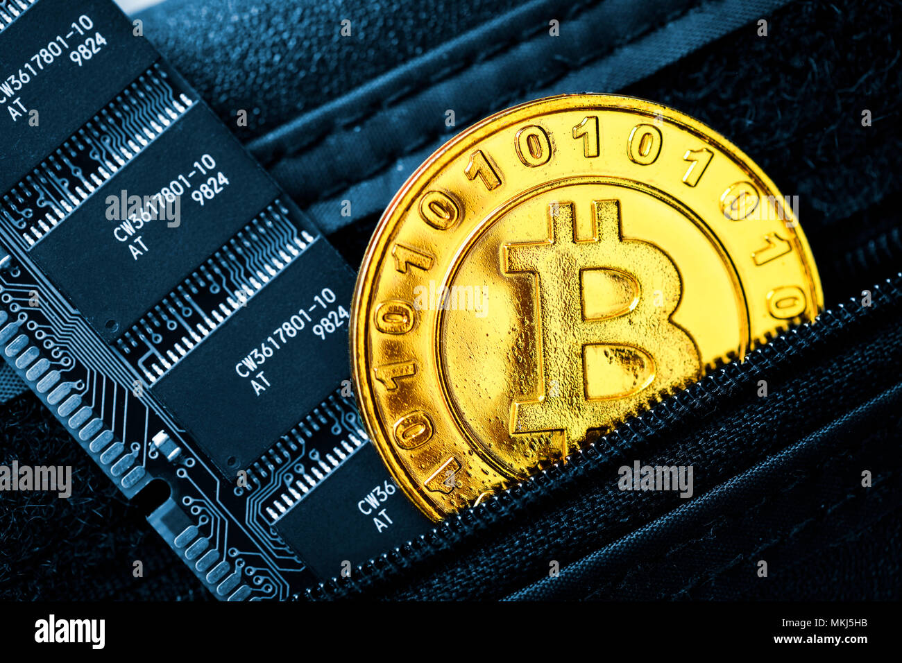 Moneta con caratteri bitcoin e circuito integrato del computer in un portafoglio Münze mit Bitcoin-Zeichen und Computerplatine in einem Portemonnaie Foto Stock
