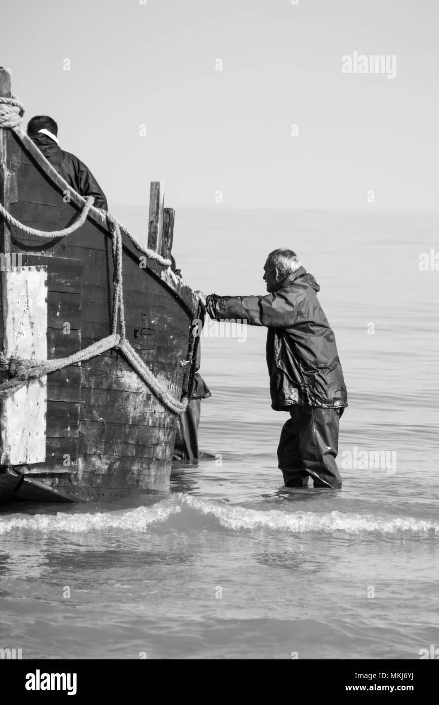L uomo e la barca da pesca Foto Stock