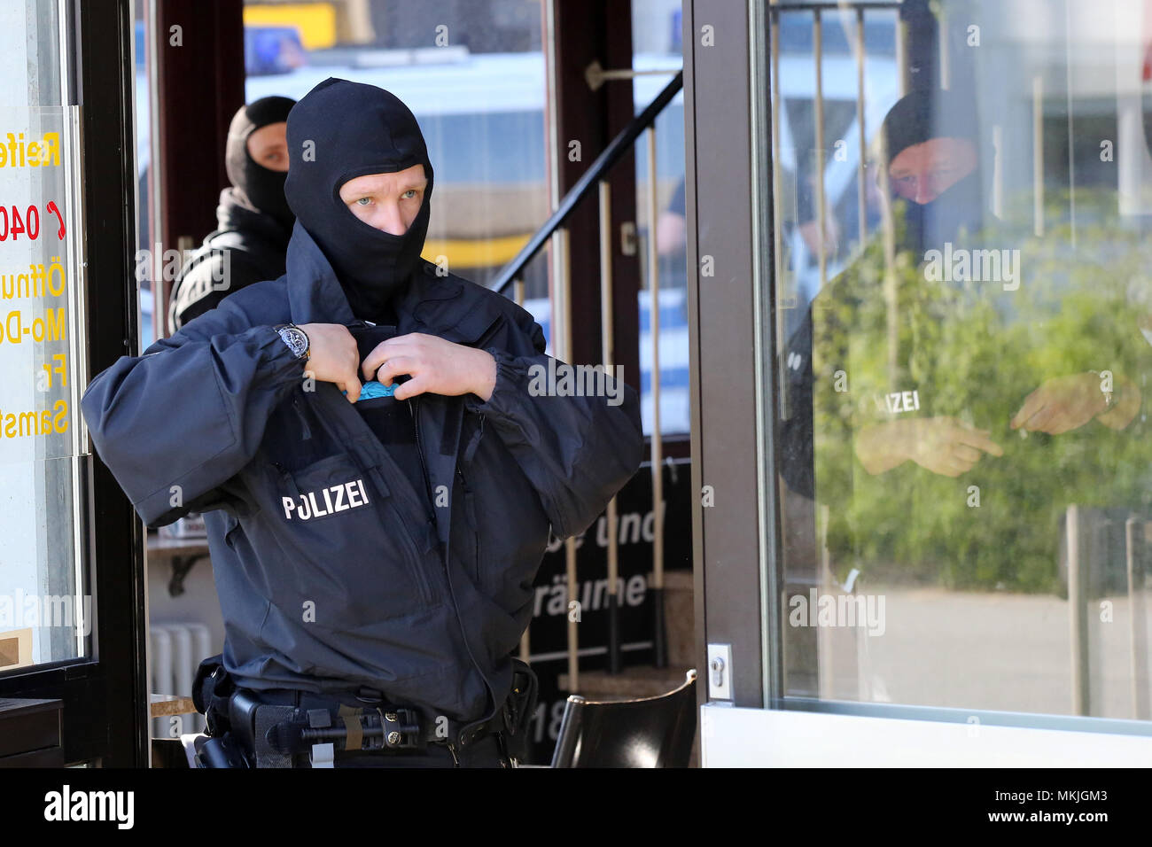 Bremen, Germania. 08 maggio 2018, Germania, Bremen: poliziotti in piedi in un edificio durante una larga scala di raid. Una pista è sospettata di traffico di centinaia di moldavi in Germania e che impiegano illegalmente in servizi di sicurezza. Foto: Bodo segna/dpa Credito: dpa picture alliance/Alamy Live News Foto Stock