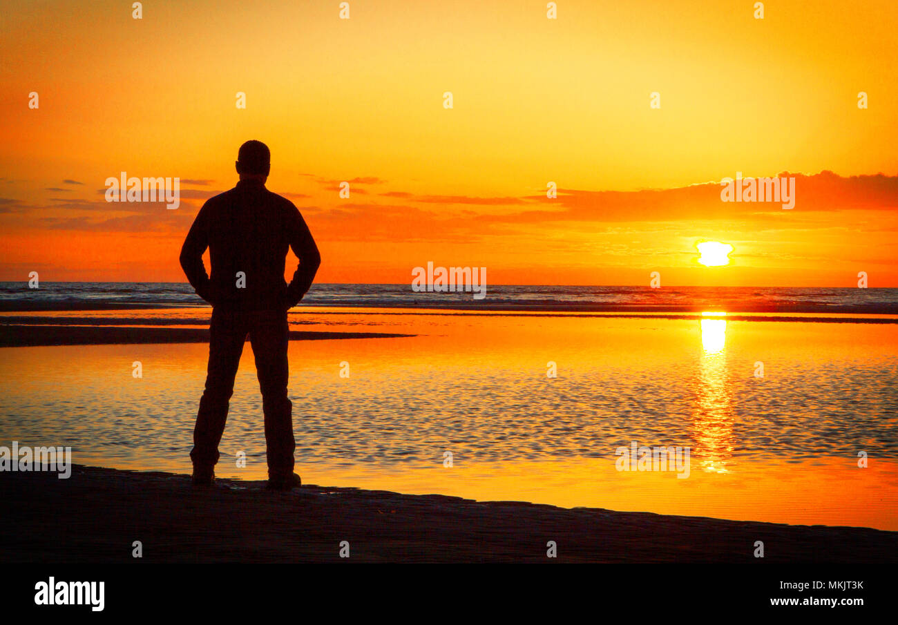 Bel Tramonto, Ainsdale, Merseyside. 8 maggio 2018. Regno Unito Meteo. Una solitaria figura sta al bordo delle acque di prendere in un tramonto mozzafiato sulla bellissima costa nord-occidentale sulla spiaggia Ainsdale nel Merseyside. Credito: Cernan Elias/Alamy Live News Foto Stock