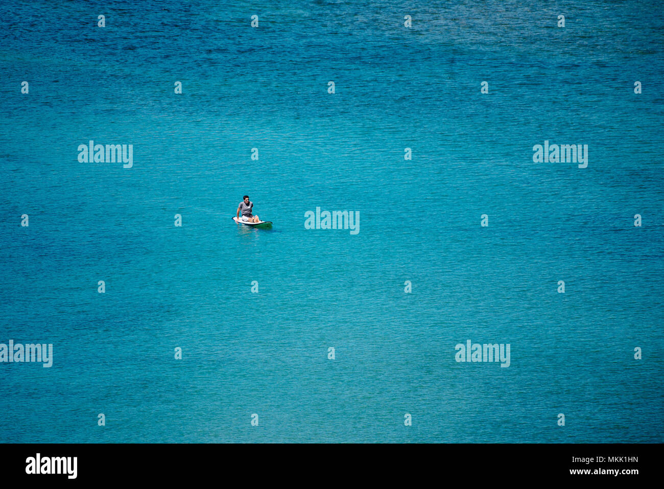 Un uomo su un SUP nel mezzo dell'oceano Foto Stock