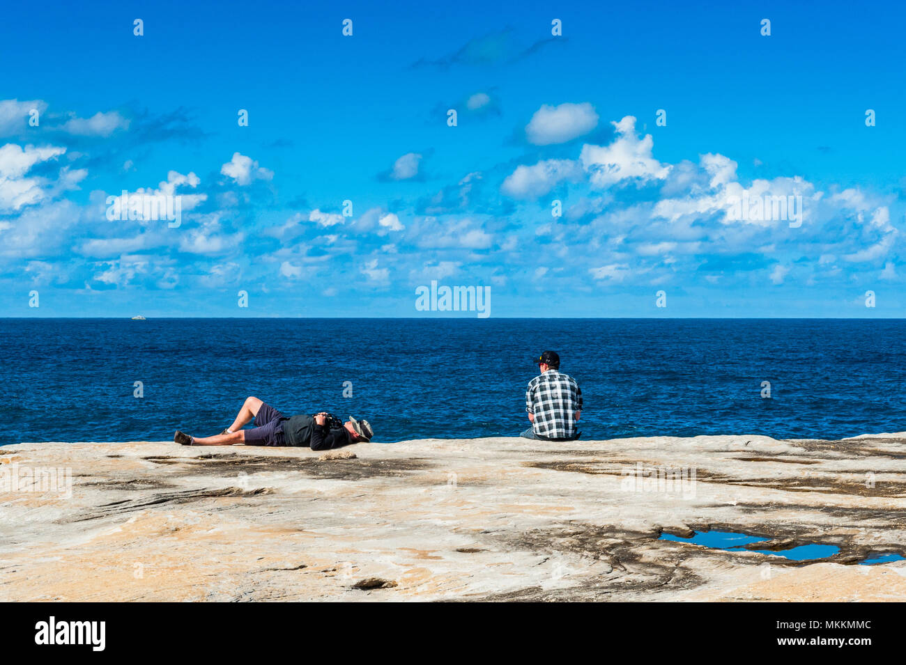 Due amici a prendere la vita facile godendo la vista e le ottime condizioni meteo lungo la famosa spiaggia di Coogee a piedi, Australia Foto Stock