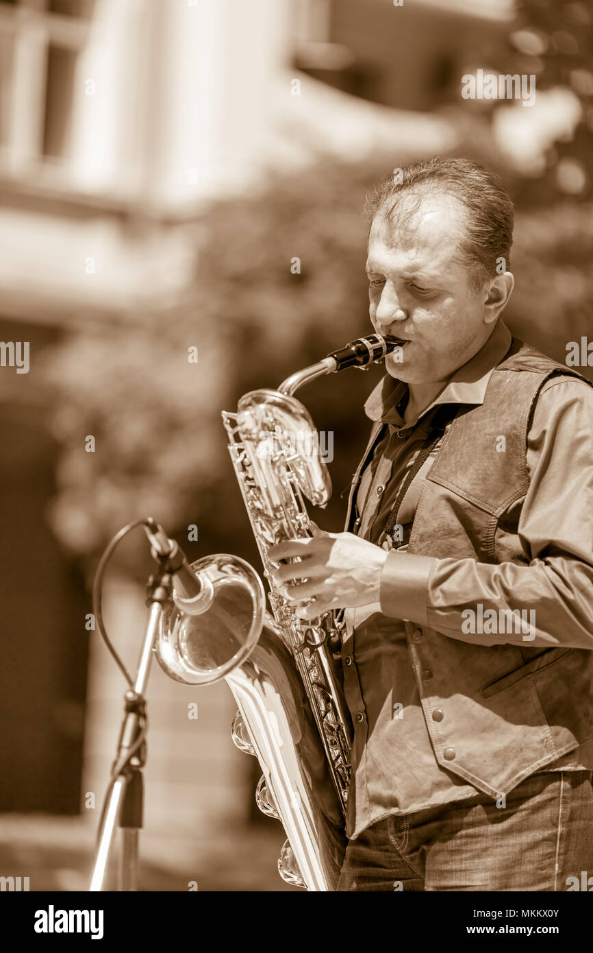 DIMITROVGRAD, Bulgaria - 30 Aprile 2018: Maschio bass sassofonista esegue la complessa e sofisticata parte musicale sul suo sax al concerto di strada evento dedicato al mondo internazionale Jazz giorno Foto Stock