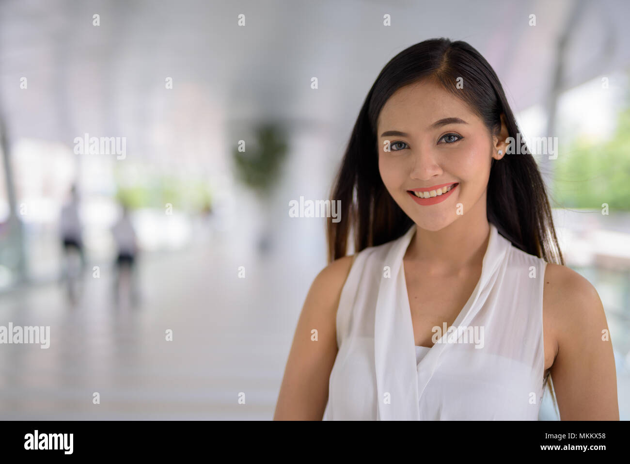 Giovane bella asiatica imprenditrice appendere fuori all'footbridg Foto Stock