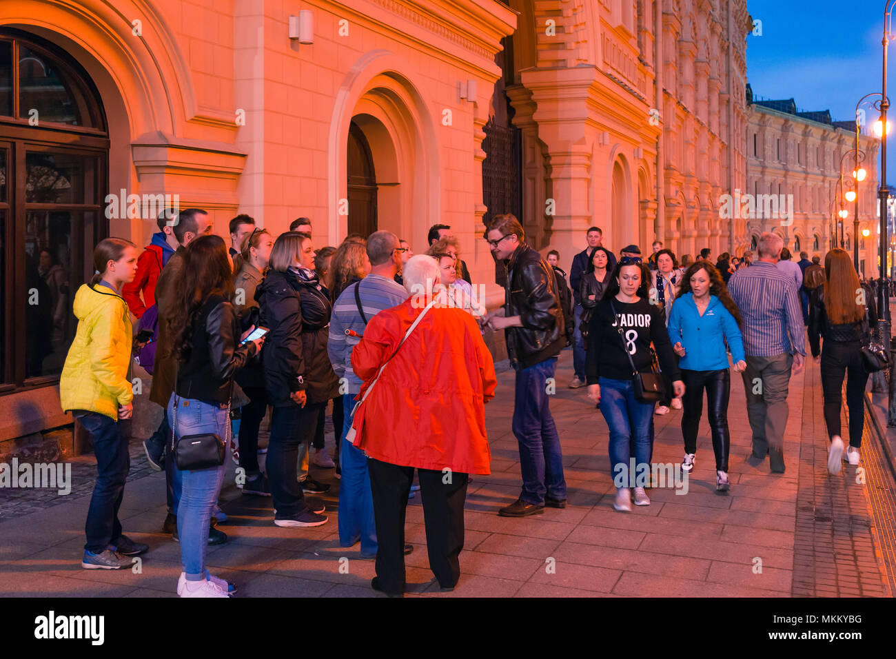 Mosca, Russia - 30 Aprile 2018: una guida con un gruppo di turisti vicino alla Cattedrale di San Basilio sulla Piazza Rossa. Di sera, al tramonto prima del tramonto. Foto Stock