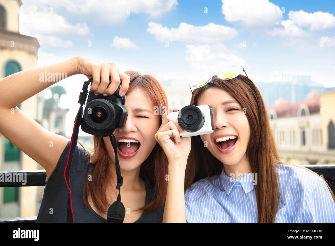 Due ragazze felici tenere la fotocamera e il concetto di viaggio Foto Stock
