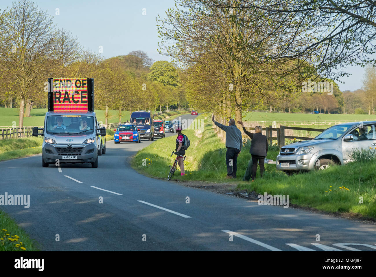 Spettatori onda al veicolo ufficiale contrassegno di fine del Tour de Yorkshire 2018 gara su New Scenic 5 posti, paese lane - Ilkley, North Yorkshire, Inghilterra, Regno Unito. Foto Stock