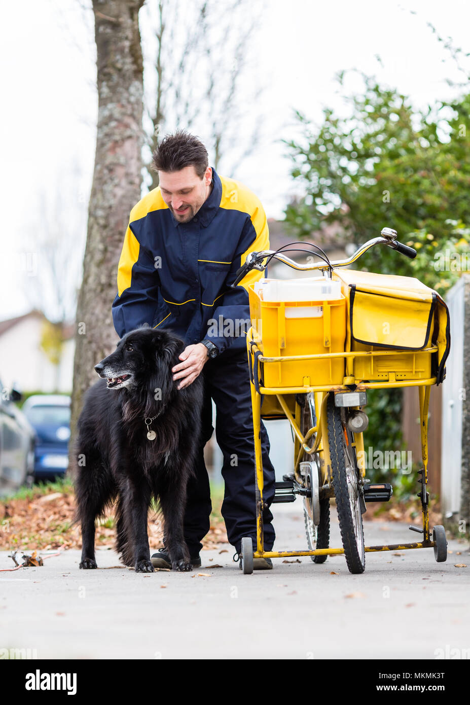 Grande cane nero accogliente portalettere al cancello del giardino Foto Stock