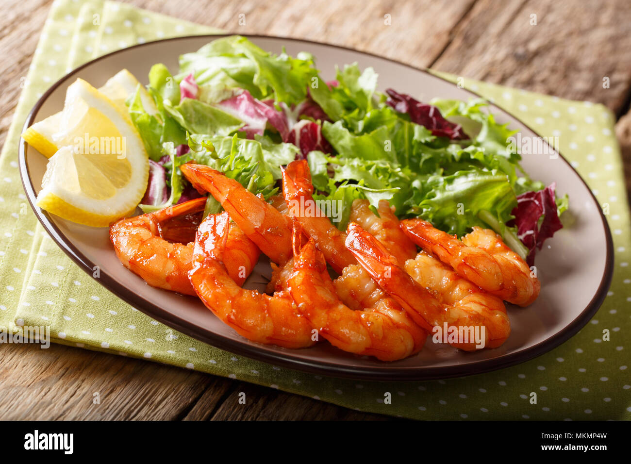 Gamberi caramellate con miele e la salsa di soia e di lattuga fresca  close-up su una piastra sul tavolo orizzontale Foto stock - Alamy