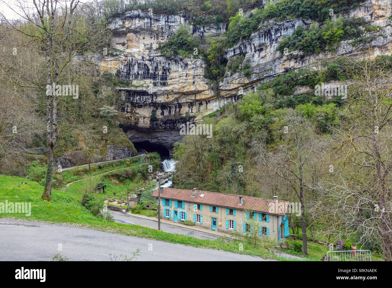Cottages e il fiume che scorre attraverso l'entrata sud della grotta preistorica Mas-d'Azil, Midi-Pirenei, Pirenei, Francia Foto Stock