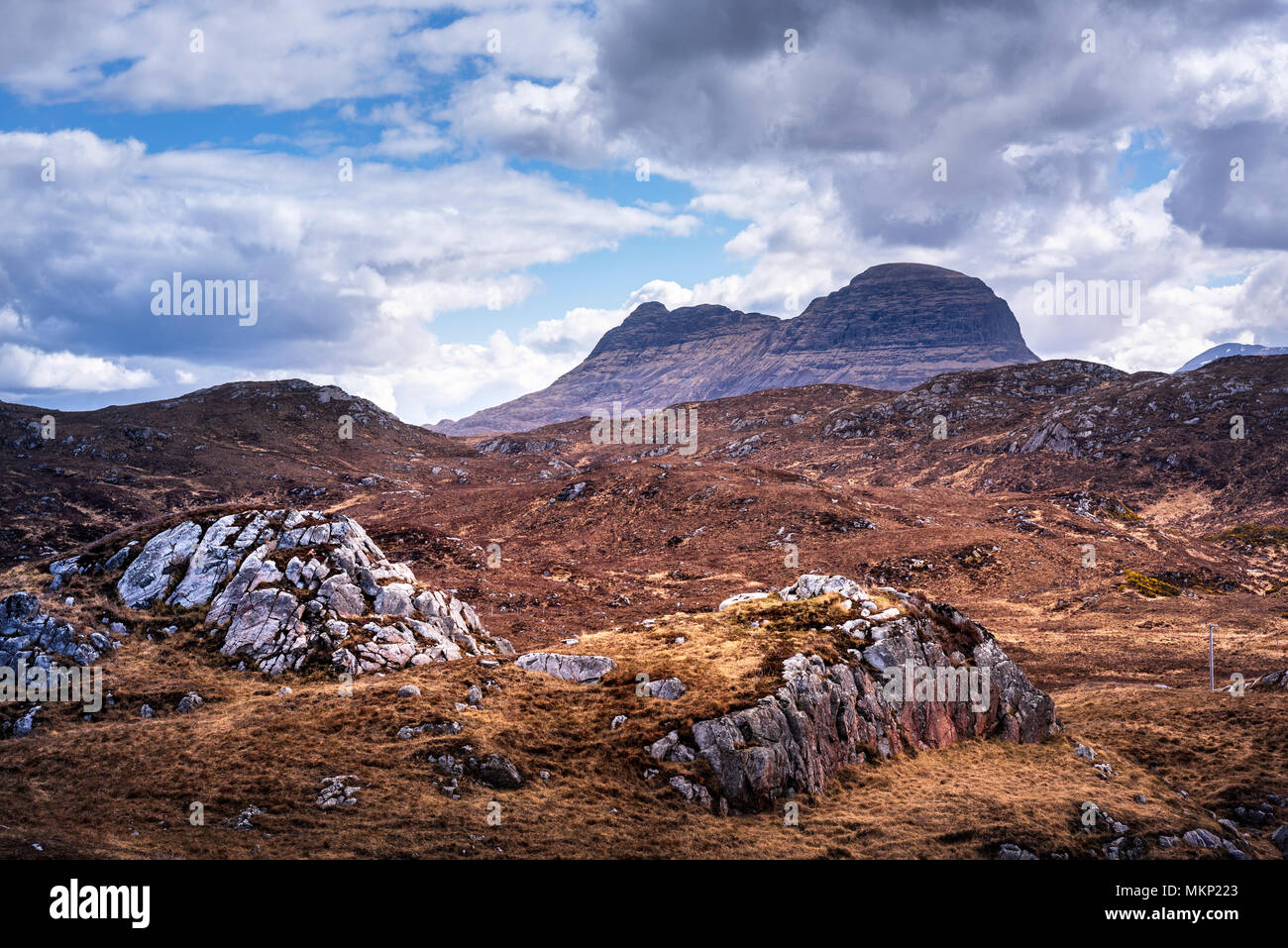 Highlands scozzesi robusto brughiera e paesaggio di montagna vicino a Lochinver in Assynt con drammatica Suilven nella distanza Foto Stock