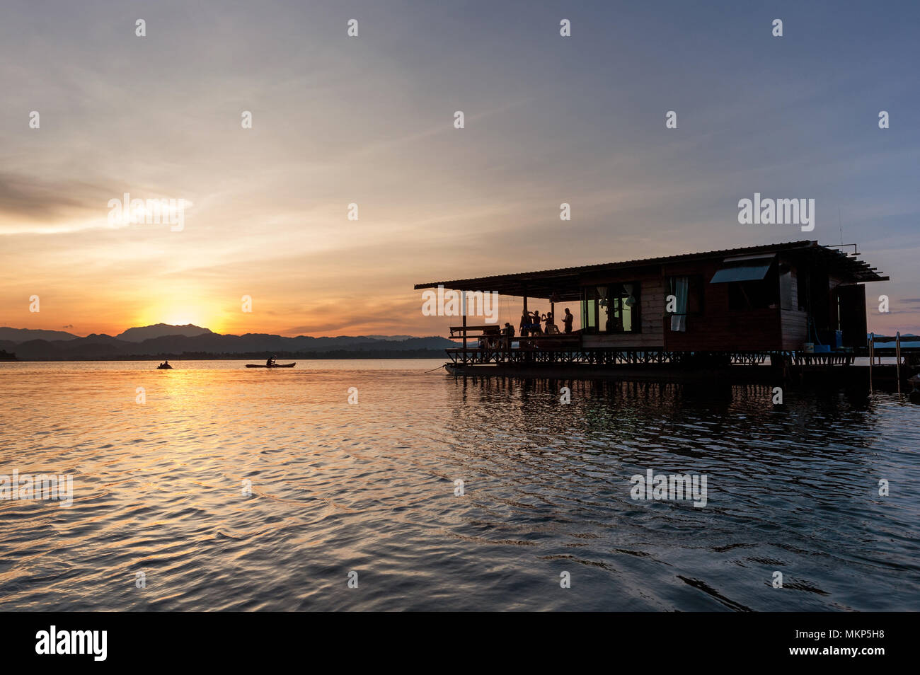 Casa galleggiante rafting al tramonto sul lago Foto Stock