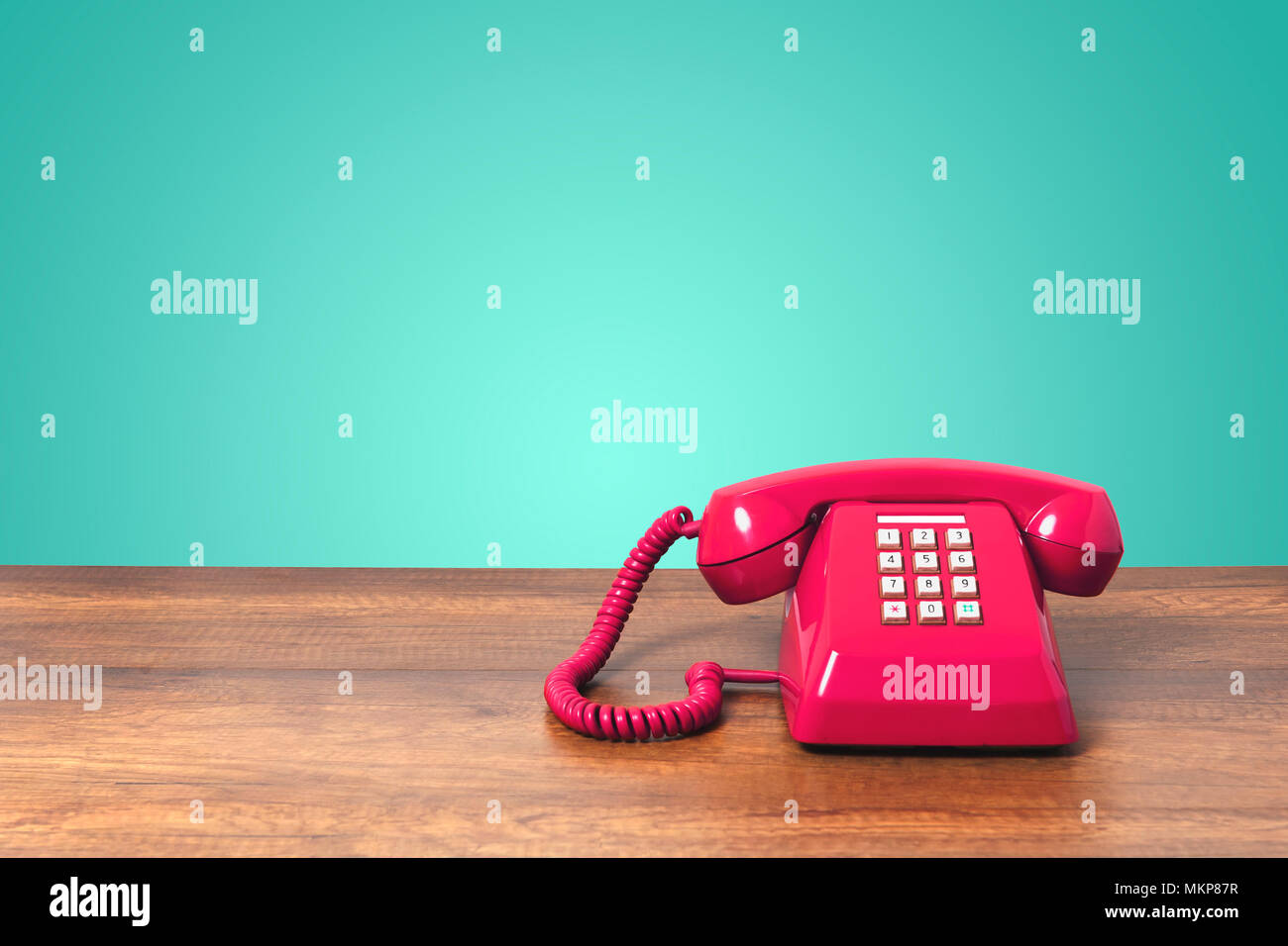 Retrò telefono rosa sulla tavola di legno sulla parete acquamarina colore di sfondo Foto Stock