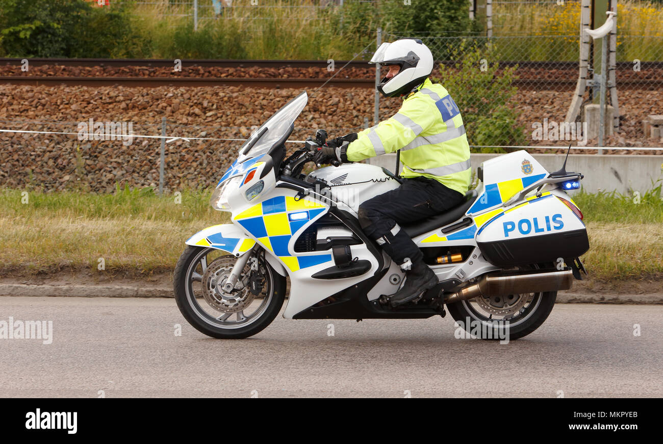 Vasteras, Svezia - Luglio 5, 2013: svedese poliziotto è alla guida di una motocicletta di polizia sulla strada vicino alla ferrovia. Foto Stock
