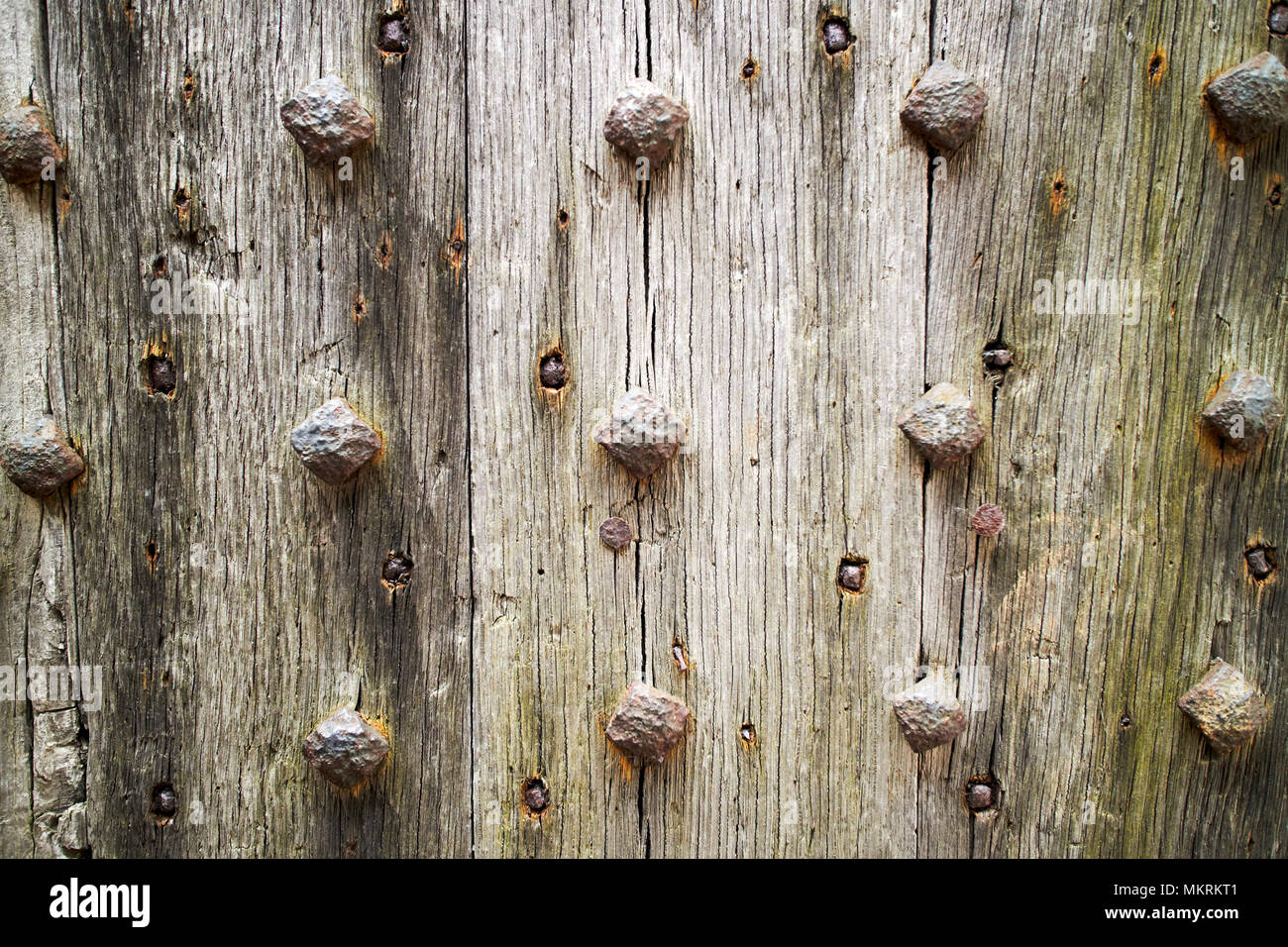 Costellato di ferro vecchio porta in legno di quercia per la serratura fino a Lacock village Wiltshire, Inghilterra Regno Unito Foto Stock