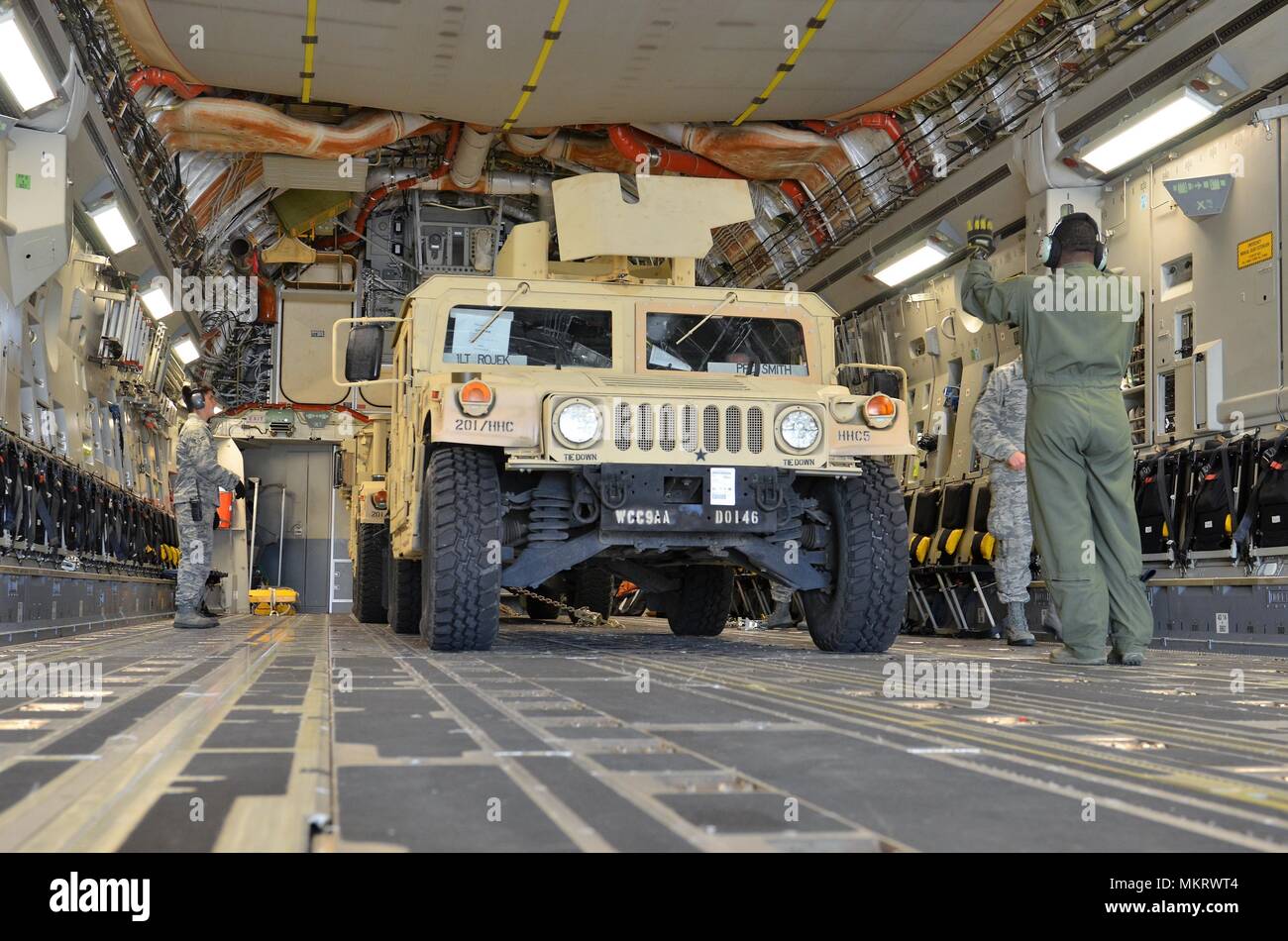 Una forza aerea loadmaster da 62o Airlift Wing a base comune Lewis-Mccorda, nello Stato di Washington dirige il caricamento di un M1151 Humvee (HMMWV) su un C-17 Globemaster III Maggio 7, 2018 Maggio 7, 2018. La M1151 Enhanced Armament Carrier è una versione migliorata del HMMWV standard utilizzato per spostare truppe. Il movimento è parte di una formazione sul campo esercizio essendo condotta dal 201st Expeditionary Intelligence militare e dei vigili del fuoco è stato progettato per rendere più realistiche le formazione di carico per la Air Force e più airlift preparazione delle apparecchiature di formazione per l'esercito. (U.S. Foto dell'esercito da Staff Sgt. Chris McCullough). () Foto Stock