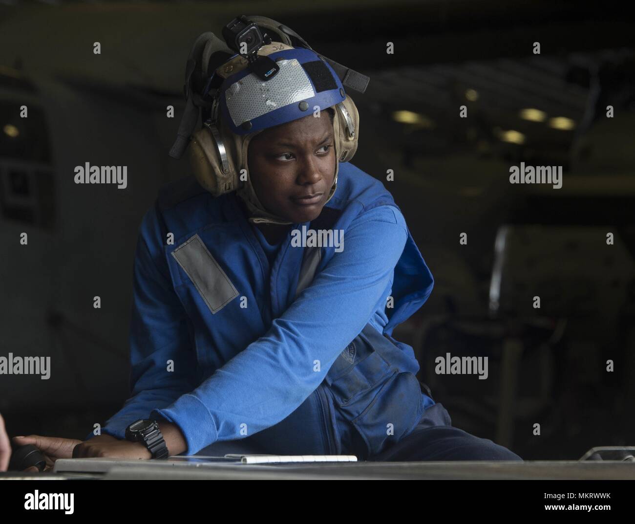 180507-N-AH771-0021 U.S. 5TH FLOTTA AREA DI OPERAZIONI (7 maggio 2018) di aviazione di Boatswain Mate (manipolazione) Airman Khalyne Jones, da Marshall, Texas, aziona un come-32A spotting dolly in hangar bay a bordo il Wasp-classe assalto anfibio nave USS Iwo Jima (LHD 7), 7 maggio 2018, 7 maggio 2018. Iwo Jima, homeported a Mayport, Fla. è sulla distribuzione per gli Stati Uniti Quinta Flotta area di operazioni a sostegno della sicurezza marittima operazioni per rassicurare gli alleati e partner e preservare la libertà di navigazione e il libero flusso di commercio nella regione. (U.S. Foto di Marina di Massa lo specialista di comunicazione 3 Foto Stock