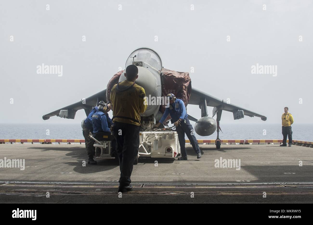 180507-N-AH771-0071 U.S. 5TH FLOTTA AREA DI OPERAZIONI (7 maggio 2018) i marinai a bordo del Wasp-classe assalto anfibio nave USS Iwo Jima (LHD 7) preparare un AV-8B Harrier jet attaccata al mezzo marino Tiltrotor Squadron (VMM) 162 (rinforzato), per essere spostato nella nave di hangar bay, 7 maggio 2018, 7 maggio 2018. Iwo Jima, homeported a Mayport, Fla. è sulla distribuzione per gli Stati Uniti Quinta Flotta area di operazioni a sostegno della sicurezza marittima operazioni per rassicurare gli alleati e partner e preservare la libertà di navigazione e il libero flusso di commercio nella regione. (U.S. Foto di Marina di Massa Communicatio Foto Stock