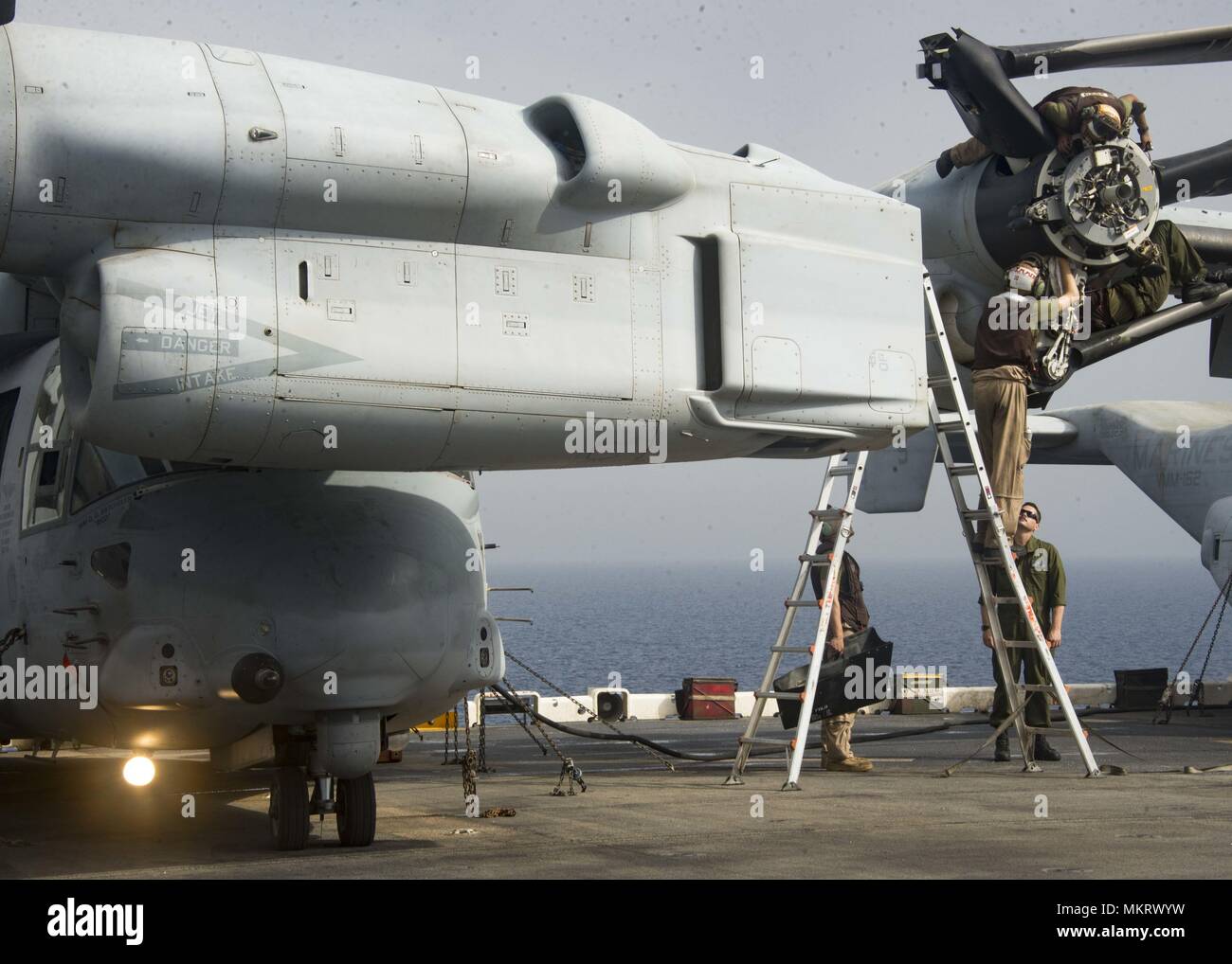 180507-N-ZG607-0102 U.S. 5TH FLOTTA AREA DI OPERAZIONI (7 maggio 2018) Marines assegnato al XXVI Marine Expeditionary Unit di eseguire le operazioni di manutenzione su una MV-22 Osprey sul ponte di volo a bordo del Wasp-classe assalto anfibio nave USS Iwo Jima (LHD 7), 7 maggio 2018, 7 maggio 2018. Iwo Jima, homeported a Mayport, Fla. è distribuito negli Stati Uniti Quinta Flotta area di operazioni a sostegno della sicurezza marittima operazioni per rassicurare gli alleati e partner e preservare la libertà di navigazione e il libero flusso di commercio nella regione. (U.S. Foto di Marina di Massa Specialista comunicazione marinaio Dominick A. crema Foto Stock