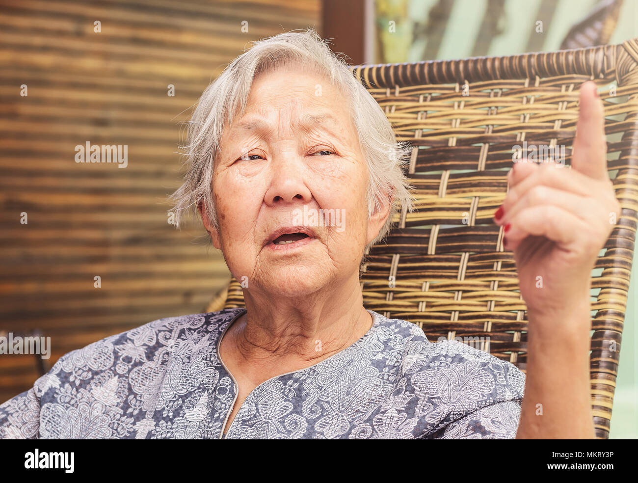 Old Lady raccontare storie. Espressione seria con il dito verso l'alto. Foto Stock