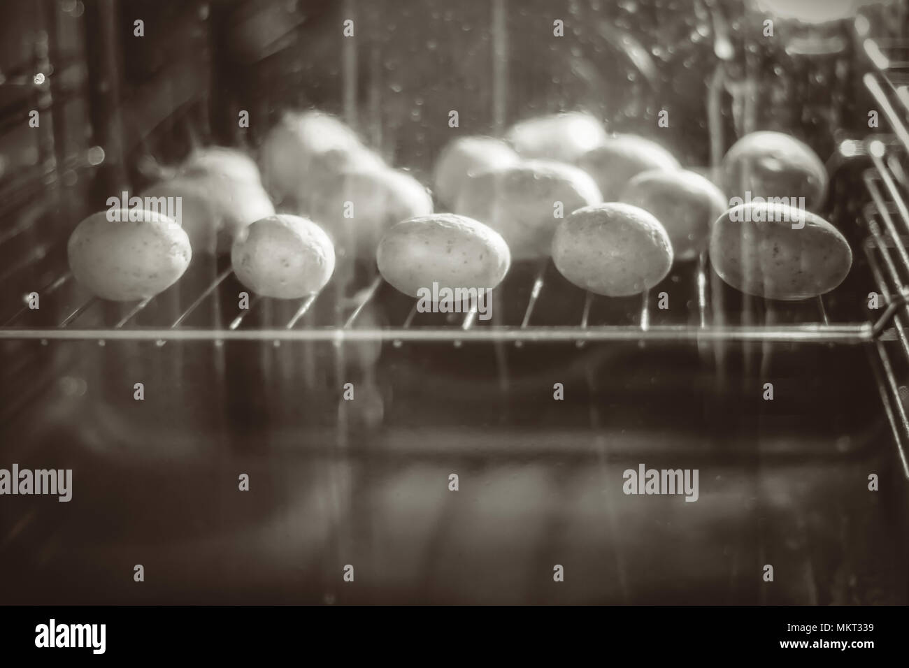 Le patate in una buccia sono cotti in un forno Foto Stock