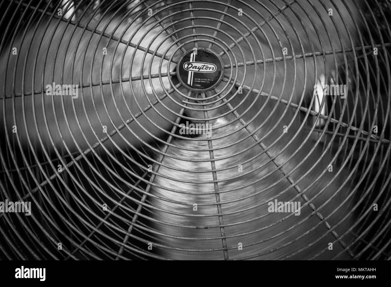 Un bianco e nero dettaglio di un grande fan piano con le sue lame metalliche in movimento Foto Stock