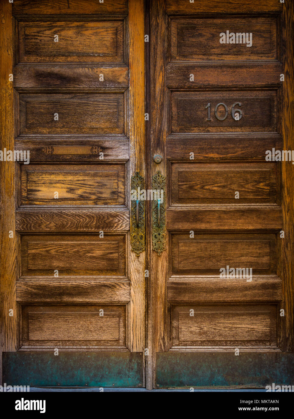 Un portale con belle venature di legno ornati e maniglie in ottone Foto Stock