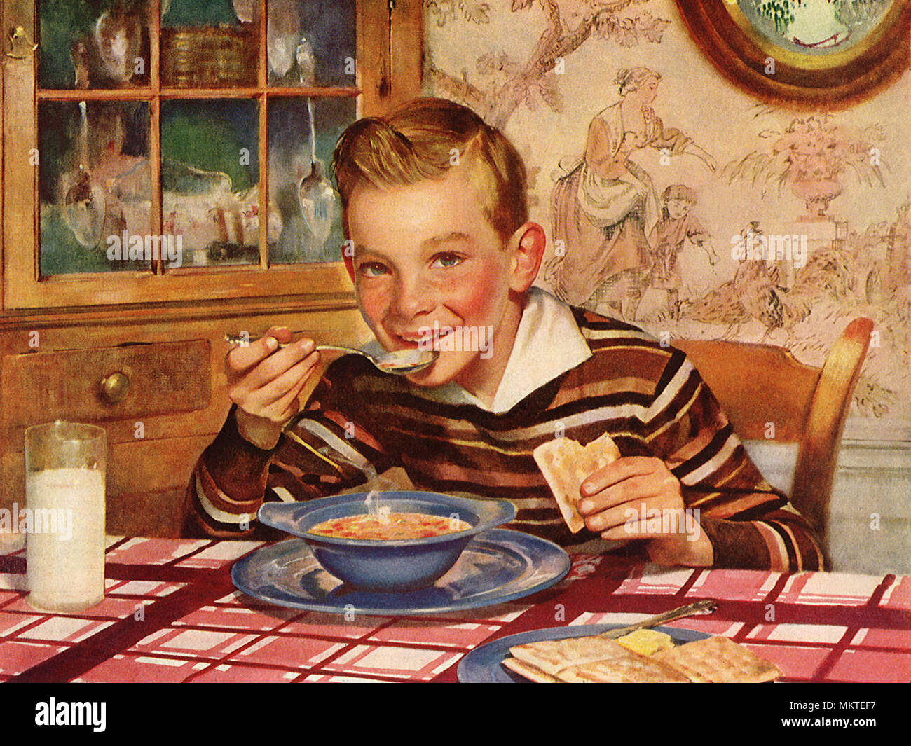 Felice ragazzo di mangiare la minestra e crackers Foto Stock