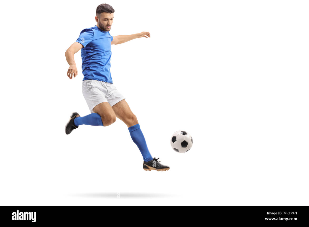 A piena lunghezza Ritratto di un giocatore di calcio a mezz aria calci un calcio isolati su sfondo bianco Foto Stock