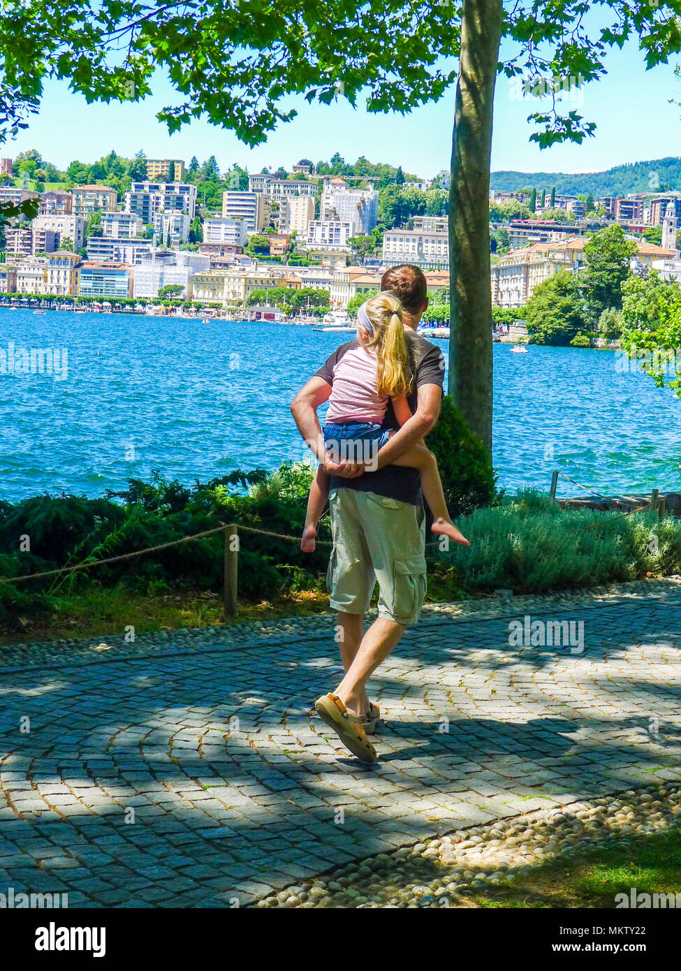 Padre figlia papà bambino ragazza kid piggyback piggy back estati soleggiate giorno, la vita della famiglia di Lugano, Svizzera spensierata felice di vita vita migliore amore familiare Foto Stock