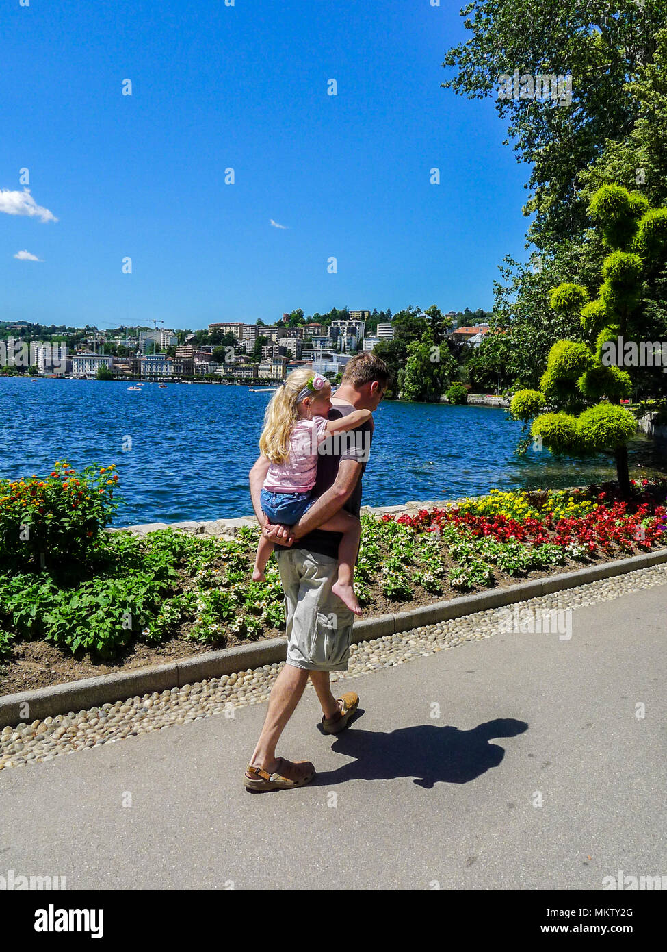 Padre figlia papà bambino ragazza kid piggyback piggy back estati soleggiate giorno, la vita della famiglia di Lugano, Svizzera spensierata felice di vita vita migliore amore familiare Foto Stock