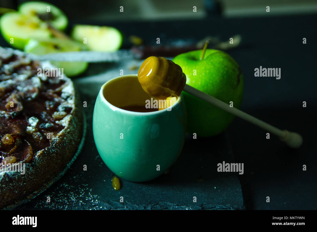 Torta di mele con crema al caramello sulla tavola nera con zucchero in background e Apple Foto Stock