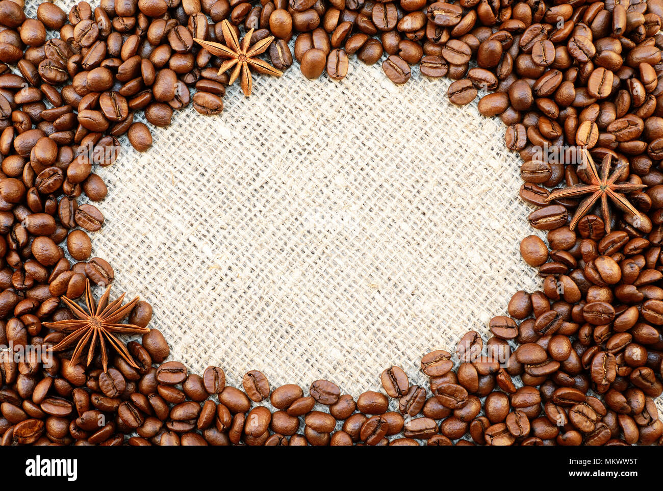 I chicchi di caffè con anisetree stelle cornice ovale sul naturale saccheggi sfondo con lo spazio per il tuo testo. Foto Stock