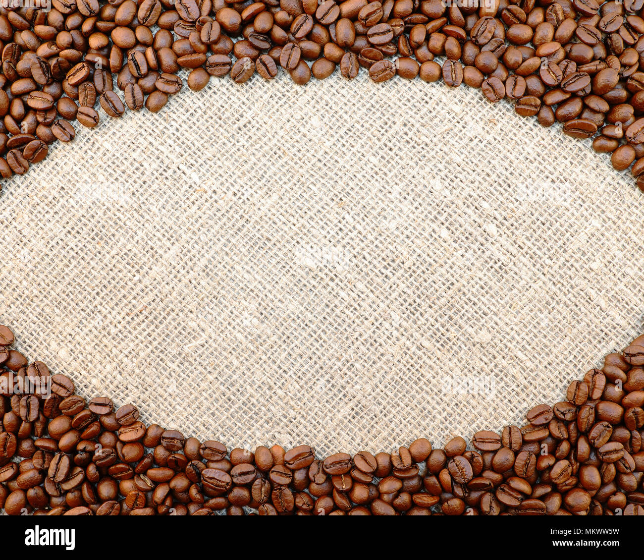 I chicchi di caffè cornice ovale sul naturale saccheggi sfondo con lo spazio per il tuo testo. Foto Stock