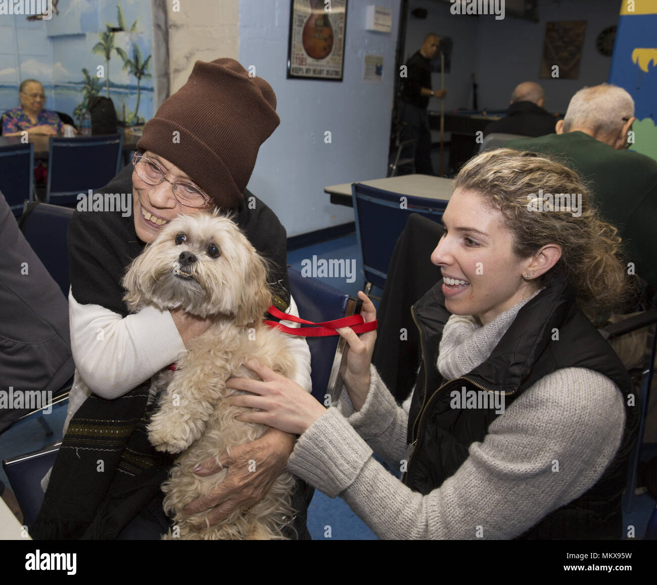 Terapista del cane con cane terapia visiti regolarmente un senior center sulla Lower East Side di Manhattan, New York City. Foto Stock