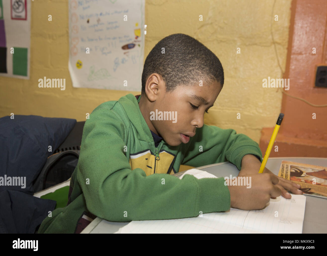 I bambini fare i compiti di scuola a un dopo la scuola un centro comunitario sul programma il Lower East Side di Manhattan, New York City. Foto Stock