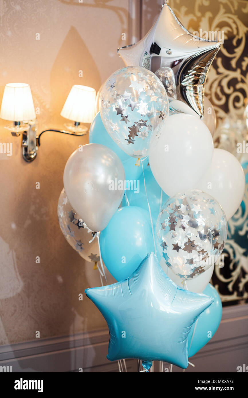Compleanno photo zone con bianco, blu e palloncini trasparenti, spazio libero. Palloncini colorati sfondo, Foto Stock