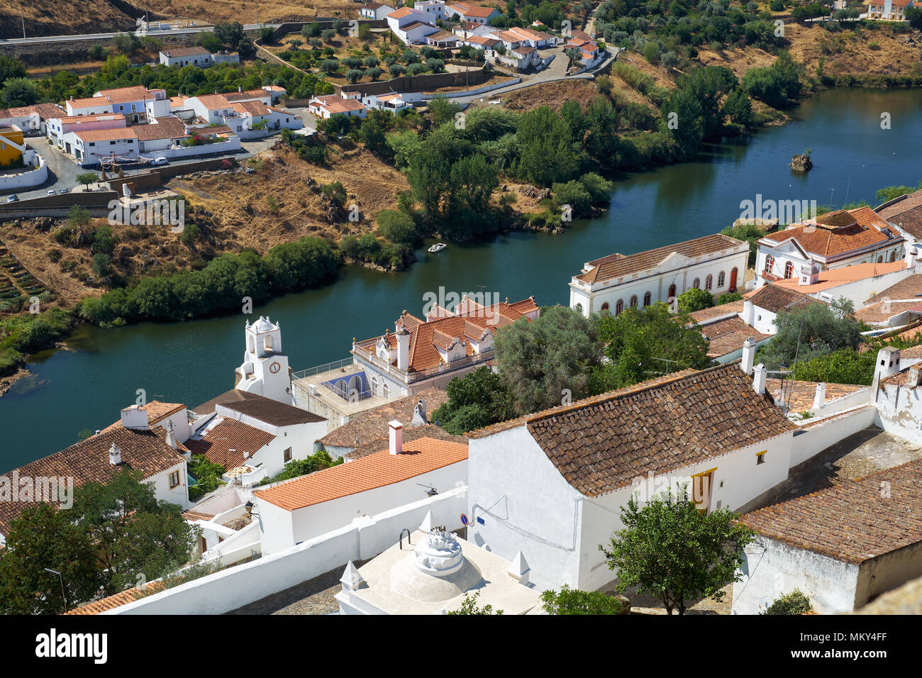 La vista del fiume Guadiana con le case residenziali e di Clock Tower (Torre do Relogio) costruito in una delle torri della cinta muraria della città sulla destra Foto Stock