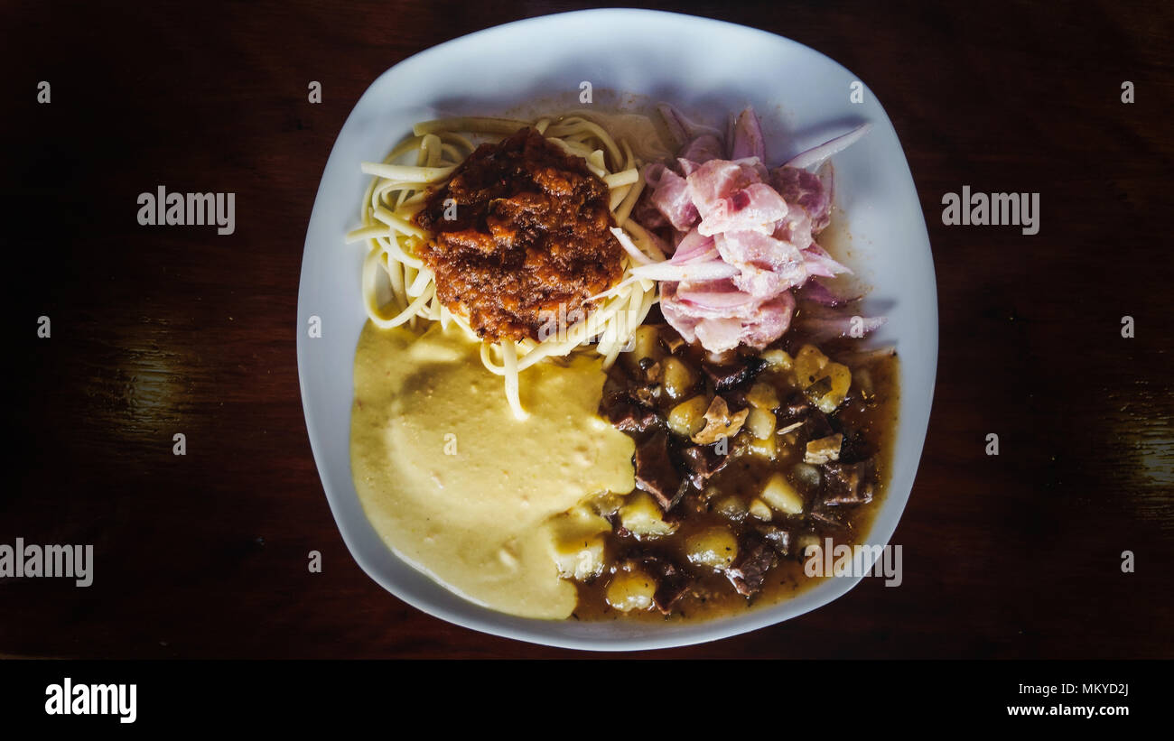 Culinarie peruviane: chanfainita con tallarines, ceviche e salsa huancaina Foto Stock