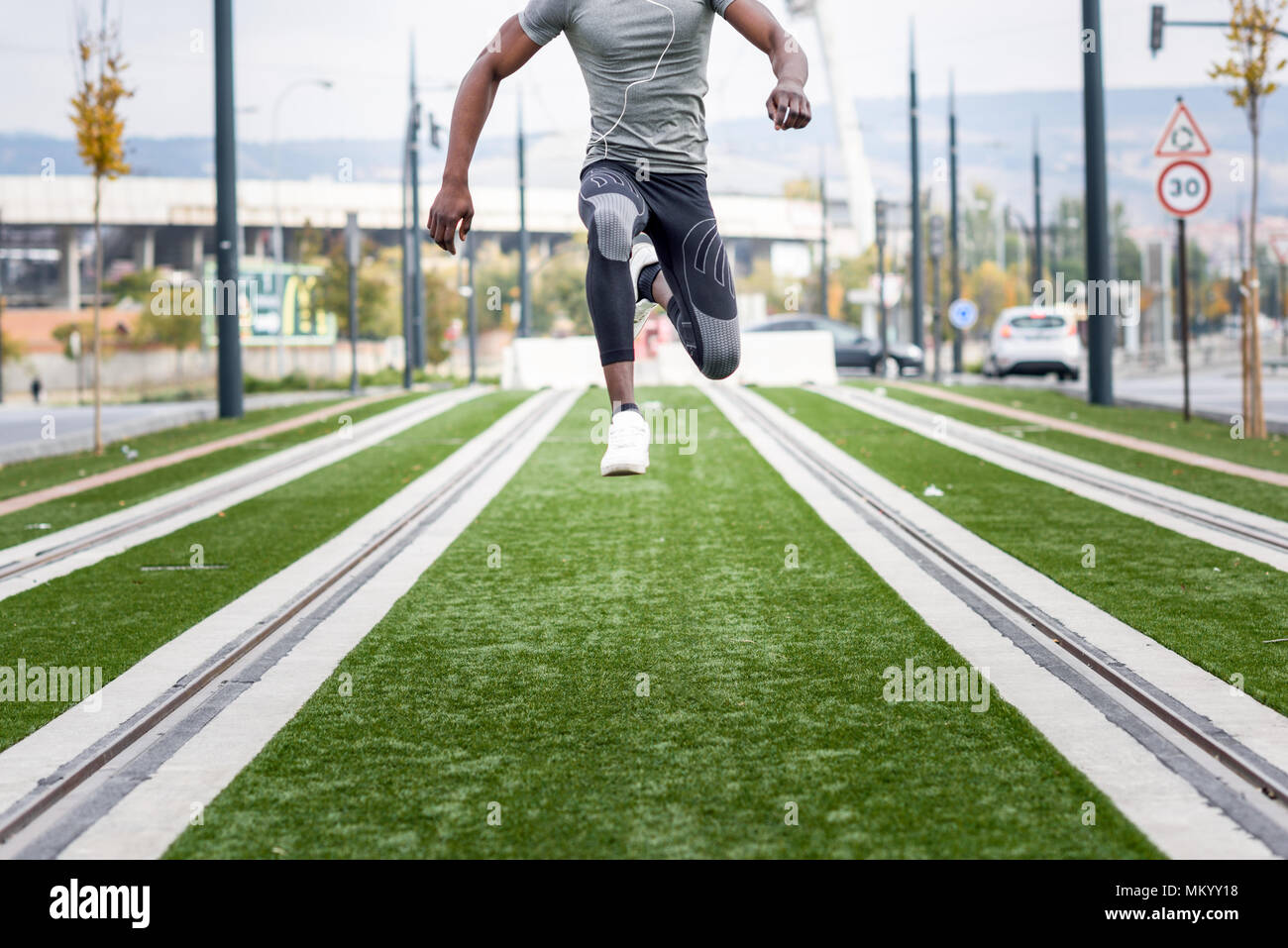 Uomo nero saltando in background urbano. Maschio di allenamento facendo in strada. Foto Stock