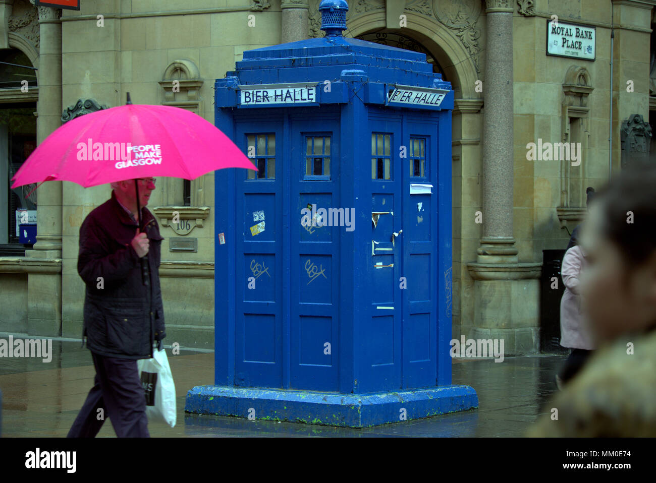 Glasgow, Scotland, Regno Unito 9 Maggio. Royal bank posto il sito della nuova ivy ristorante con le persone fanno di Glasgow ombrello rosa UK Meteo Buchanan Street con i suoi tardis è un FIR a la mecca per i turisti che visitano la città nel cuore della città offre poco per il turista come noioso wet weather pervade dopo la banca a caldo vacanza.. Gerard Ferry/Alamy news Foto Stock