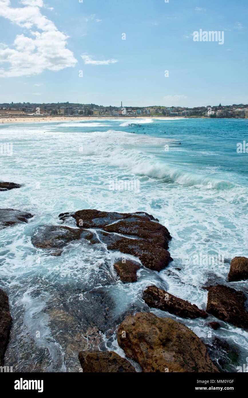 Vista dal nord attraverso le onde che si infrangono lungo la spiaggia di Bondi Foto Stock