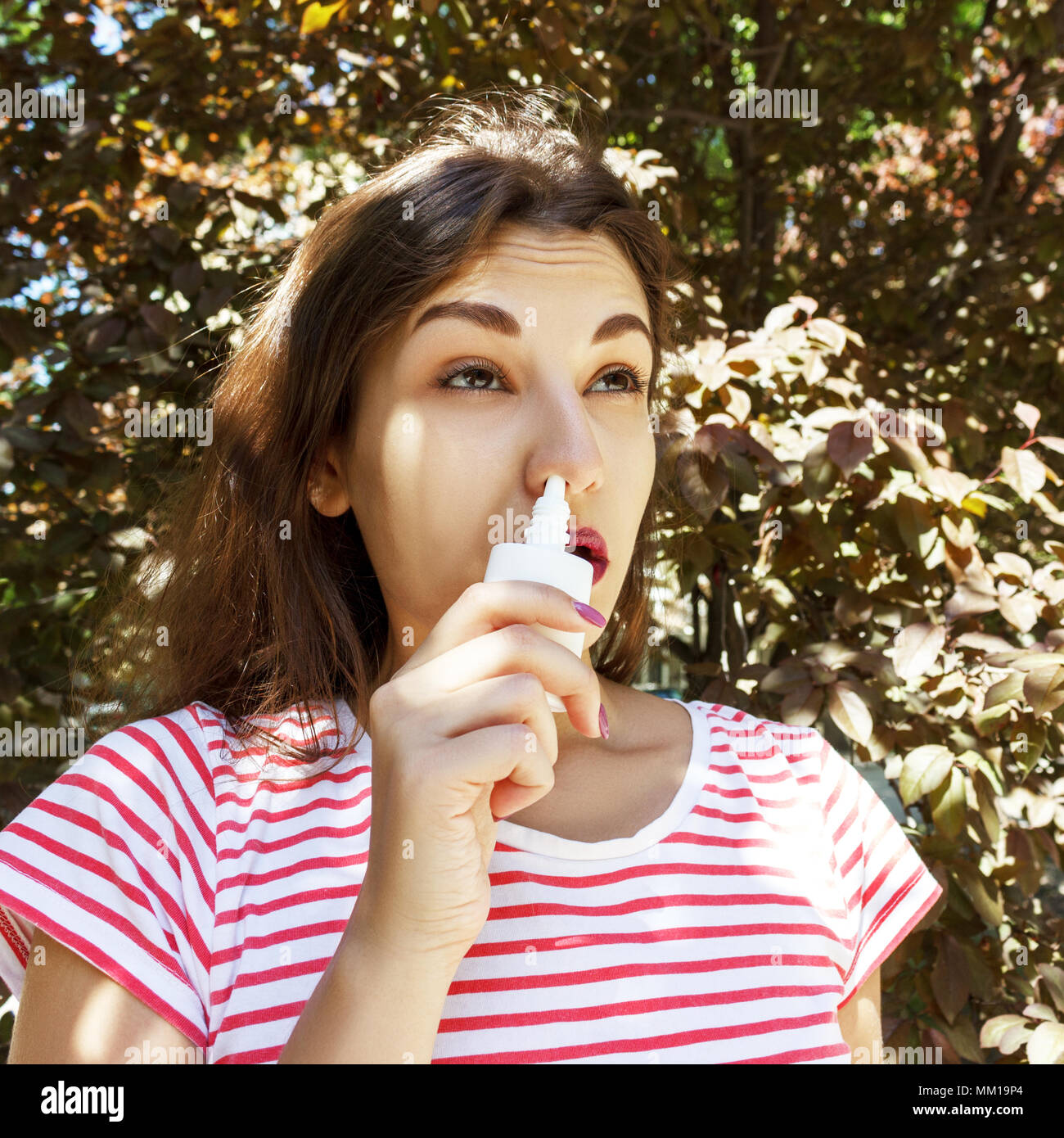 Una donna è il gocciolamento gocce nasali in un naso chiuso. La malattia e la malattia. Trattamento di sinusite e allergie. concetto medico. Foto Stock