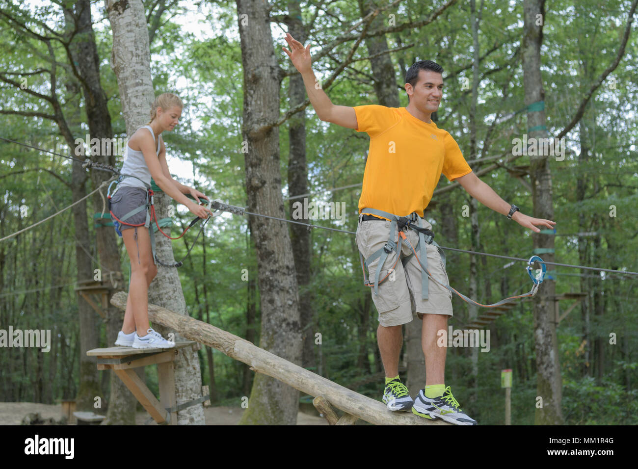 Giovane uomo e donna divertendosi in alberi Foto Stock