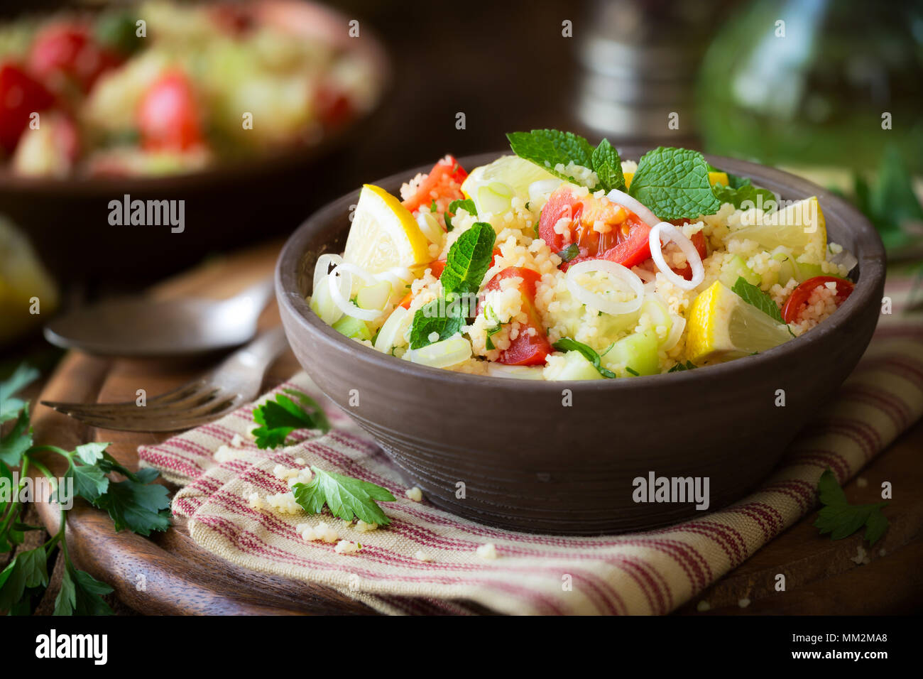 Tabulé vegetariano - deliziosa cuscus con insalata di pomodori ciliegini, cetrioli, menta fresca e foglie di prezzemolo. Foto Stock